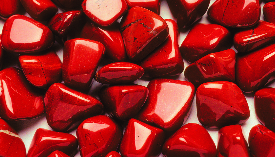 Polished red jasper stones with a rich, earthy red hue and subtle natural patterns, highlighting its smooth texture and grounding energy.